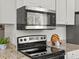Close up on the stainless steel stove and microwave in the kitchen at 4858 S Quintero Cir, Aurora, CO 80015