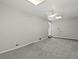 A carpeted living room features a ceiling fan and neutral-painted walls at 4858 S Quintero Cir, Aurora, CO 80015