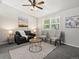 Comfortable living room with neutral walls, carpet, a ceiling fan, a large window, and cozy seating at 4858 S Quintero Cir, Aurora, CO 80015