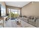 Large living room featuring glass doors to outdoor balcony with nature views at 6000 W Floyd Ave # 214, Denver, CO 80227
