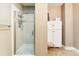 Bathroom shower with glass door and white tile at 6000 W Floyd Ave # 214, Denver, CO 80227
