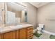 Bathroom with a oak vanity, large mirror, and green bath mats at 6000 W Floyd Ave # 214, Denver, CO 80227