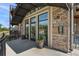 Building entrance with stacked stone, security system, and potted plants at 6000 W Floyd Ave # 214, Denver, CO 80227