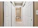Hallway with carpet flooring and double closets, leading to the bathroom at 6000 W Floyd Ave # 214, Denver, CO 80227