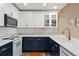 Modern kitchen with white upper cabinets, blue lower cabinets, and stainless steel appliances at 6000 W Floyd Ave # 214, Denver, CO 80227