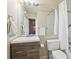 Cozy bathroom with a wood vanity, toilet, and a mirror reflecting the shower at 5708 E 10Th Ave, Denver, CO 80220