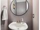 Bathroom features a white sink, round mirror, and painted walls at 5708 E 10Th Ave, Denver, CO 80220