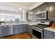 Modern kitchen featuring stainless steel appliances, granite countertops, and sleek gray cabinetry at 5708 E 10Th Ave, Denver, CO 80220