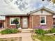 Charming brick home featuring a landscaped front yard with purple irises and a cozy front entrance at 1965 Havana St, Aurora, CO 80010