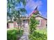 Charming brick home with a lush front yard, pergola entrance, and an American flag at 1965 Havana St, Aurora, CO 80010