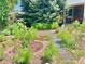 A lush flower garden with a stone pathway, brick edging, and vibrant greenery at 1965 Havana St, Aurora, CO 80010