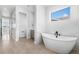 Bright bathroom featuring a soaking tub, gray vanity, and tile flooring at 6633 Bridlespur St, Castle Pines, CO 80108