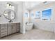 Bright bathroom featuring a soaking tub, gray vanity, and modern lighting and fixtures at 6633 Bridlespur St, Castle Pines, CO 80108