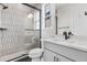 Bathroom with black trim glass shower, light grey tiles and white vanity at 6633 Bridlespur St, Castle Pines, CO 80108
