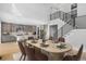 Well-lit dining area with staircase, an elegant dining table, and open access to kitchen at 6633 Bridlespur St, Castle Pines, CO 80108