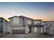 Beautiful two-story home with gray siding, stone accents, a covered porch and a two car garage under a colorful sky at 6633 Bridlespur St, Castle Pines, CO 80108