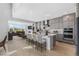 Open kitchen with stainless appliances, marble backsplash, island and seating at 6633 Bridlespur St, Castle Pines, CO 80108