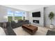 Bright living room featuring stylish furnishings, a cozy fireplace and large windows with picturesque views at 6633 Bridlespur St, Castle Pines, CO 80108