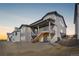 Rear exterior view of gray two-story home with deck, stairs and a well-maintained yard at 6633 Bridlespur St, Castle Pines, CO 80108