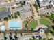 Aerial view showcases community pool, park, parking, and nearby buildings in a well-designed layout at 8367 Devinney St, Arvada, CO 80005
