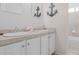 Elegant bathroom featuring dual sinks, stylish fixtures, white cabinets, and decorative seashell accents at 8367 Devinney St, Arvada, CO 80005