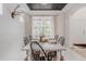 Bright dining room features a rustic table, modern chairs, and a large window, creating an inviting space for meals at 8367 Devinney St, Arvada, CO 80005