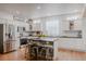 Bright, modern kitchen with white cabinets, stainless steel appliances, and a rustic island at 8367 Devinney St, Arvada, CO 80005