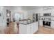 Open-concept kitchen with an island, stainless steel appliances, and hardwood floors at 8367 Devinney St, Arvada, CO 80005