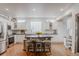 Well-lit, modern kitchen with white cabinets, stainless steel appliances, and a rustic island with stools at 8367 Devinney St, Arvada, CO 80005