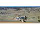 An aerial view of the property showcases its vast acreage, multiple buildings, and scenic surroundings at 2257 Deerpath Rd, Franktown, CO 80116