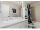 Well-lit bathroom with a white vanity and a shower/tub combination with decorative shower curtain at 2257 Deerpath Rd, Franktown, CO 80116