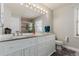 Bright bathroom with white cabinetry, dual sinks and a large mirror at 2257 Deerpath Rd, Franktown, CO 80116