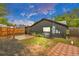 View of the fenced backyard area, showing the exterior of the house, an AC unit, and brick patio at 211 E Emma St, Lafayette, CO 80026