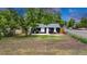 Well-maintained exterior with dark siding, green grass, trees, and a chain link fence at 211 E Emma St, Lafayette, CO 80026
