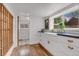 Well-lit kitchen with white cabinets, hardwood floors, and a view to the outdoors at 211 E Emma St, Lafayette, CO 80026