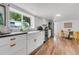 Well-lit kitchen features white cabinets, stainless appliances, and hardwood floors at 211 E Emma St, Lafayette, CO 80026