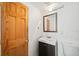 Bright bathroom features a modern vanity, square mirror, new light fixture, and a wooden door at 336 N Grant St # 302, Denver, CO 80203