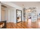 Hallway with hardwood floors leading to rooms, featuring an accent wall and a large mirror at 111 S Monroe St # B203, Denver, CO 80209