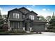 Charming two-story home with dark gray siding, stone accents, and a two-car garage at 7396 S Yank Ct, Littleton, CO 80127