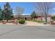 Charming brick home with mature trees, lush landscaping, and circular driveway on quiet street at 3997 S Dawson St, Aurora, CO 80014