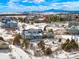 Aerial view of a neighborhood with houses, trees, and snowy mountain views in the distance at 7186 Weaver Cir, Castle Rock, CO 80104