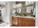 Modern bathroom featuring a double vanity, round mirrors, and wood-look accent wall for a spa-like feel at 7186 Weaver Cir, Castle Rock, CO 80104