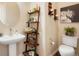Charming powder room with pedestal sink, ladder shelving, and lots of decorative touches at 7186 Weaver Cir, Castle Rock, CO 80104