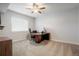 Bright bedroom with a large window, neutral carpet, ceiling fan, and an office setup at 7186 Weaver Cir, Castle Rock, CO 80104