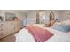 Comfortable bedroom features a bed with a pink throw and several pillows, a crib, and view to the open-concept living space at 7186 Weaver Cir, Castle Rock, CO 80104