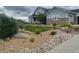 Inviting front yard with a lush green lawn, rock features, and a charming two-story home at 7186 Weaver Cir, Castle Rock, CO 80104