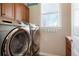 Convenient laundry room with stainless steel washer and dryer and lots of cabinet space at 7186 Weaver Cir, Castle Rock, CO 80104