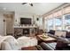 Comfortable living room features stone fireplace, TV, and lots of light from big windows with views at 7186 Weaver Cir, Castle Rock, CO 80104
