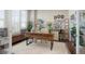 Bright and airy office space featuring a large desk, plush rug, and ample natural light at 7186 Weaver Cir, Castle Rock, CO 80104