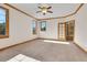 Spacious bedroom with wood trim, a ceiling fan, and natural light from three large windows at 1294 Red Lodge Dr, Evergreen, CO 80439